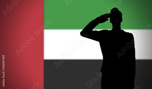 Silhouette of a soldier saluting against the uae flag