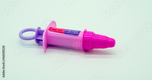 Pink plastic syringe of doctor and nurse play set
