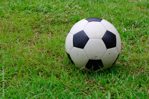 Old football on the grass field. © THAWEERAT