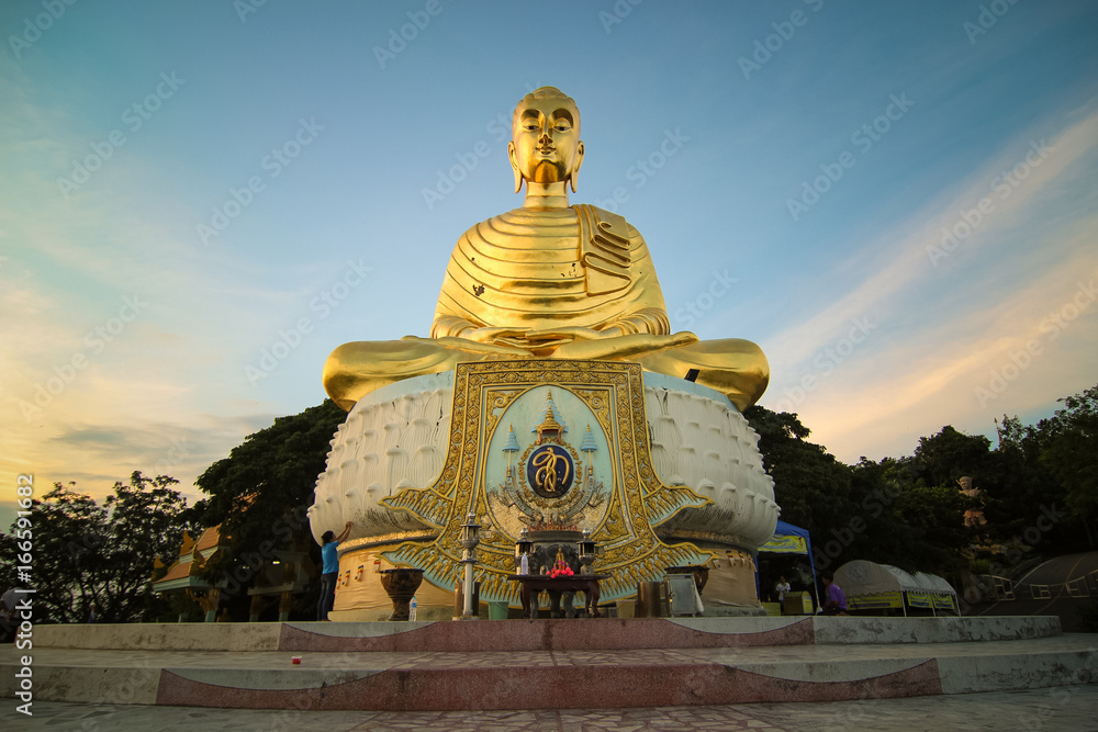 A big outdoor buddha statue with beautiful sunset background. Thailand.