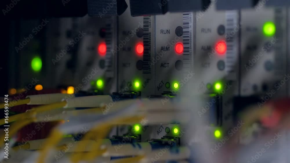 Blinking red and green indicators on network switch back panel. 4K.