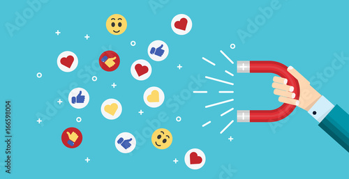 Businessman hand holding magnet attracting likes, hearts and reaction smiles.
