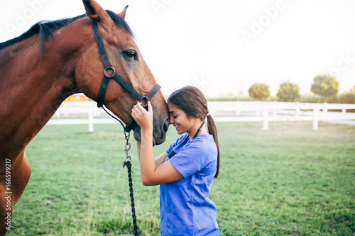 Vet petting a horse outdoors at ranch.  © hedgehog94