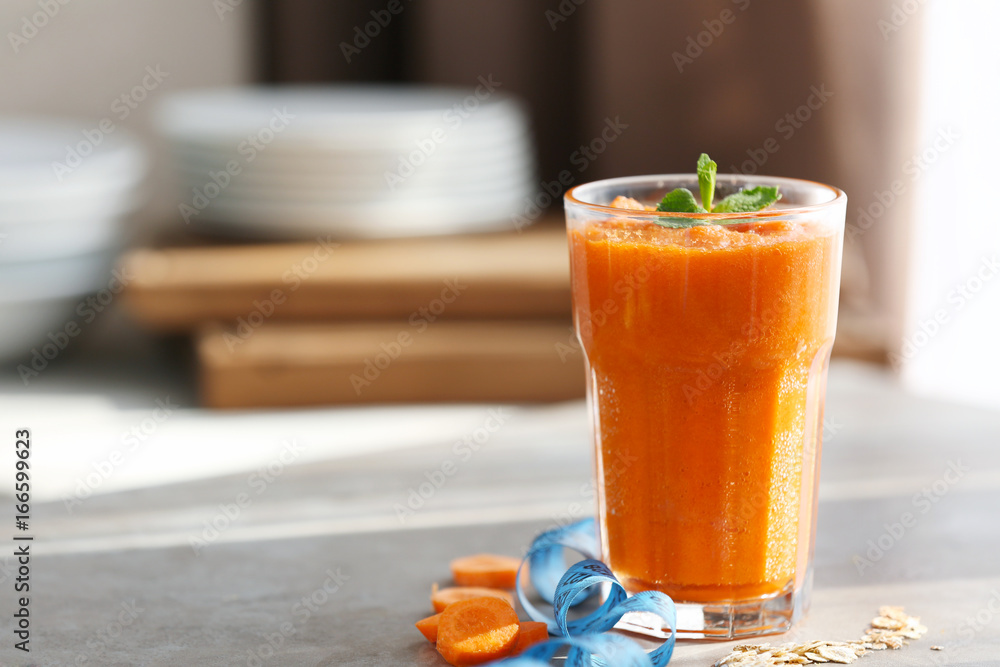 Fototapeta premium Glass with fresh tasty carrot smoothie on table