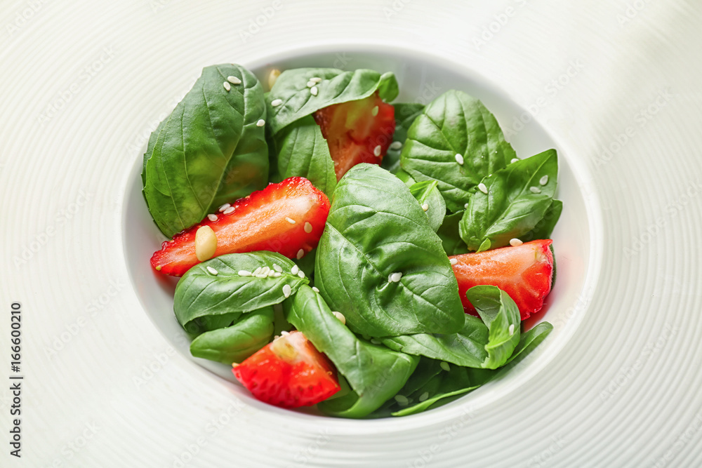 Plate with spinach leaves and strawberry, close up Plate with spinach leaves and strawberry, close up