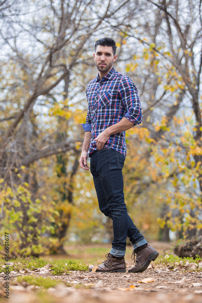 Handsome desolate man in the park. Autumn scenery Handsome desolate man in the park. Autumn scenery