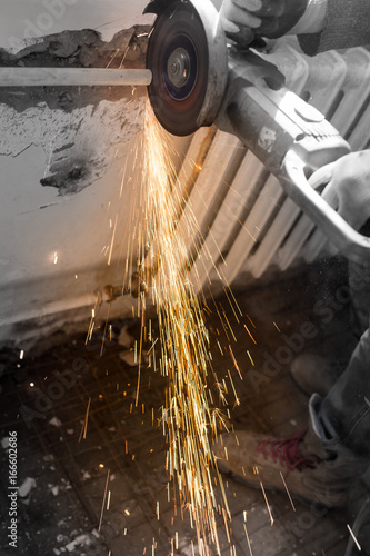 Worker cuts a metal pipe at a construction site