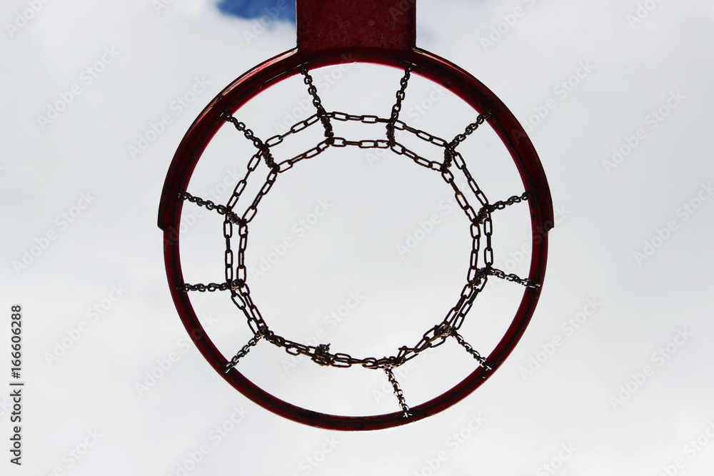 red basketball hoop view from below against the blue sky.