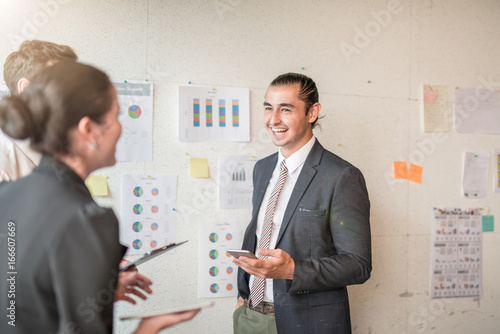 Image of Laughing and smiling businessman present discussing documents and ideas at meeting Group of business people sharing their ideas.