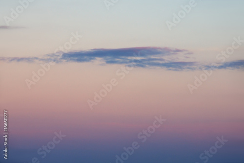 Several dark clouds on a clear sky at sunset