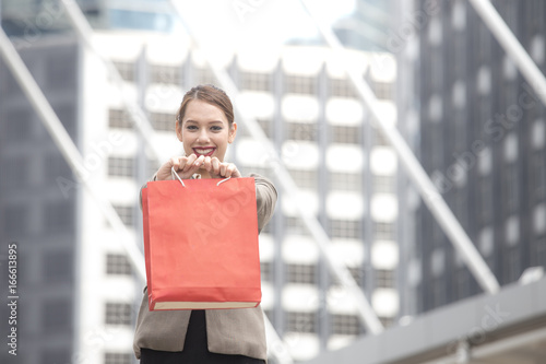 Asian Woman holding Shopping bag with attractive smile at city. Woman Shopping Concept. photo