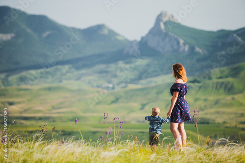 A woman with a little boy in the background of the mountains