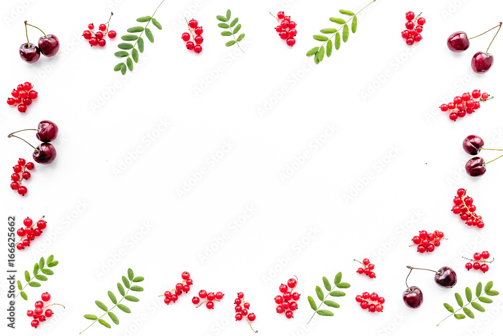 Berry frame. Red currant, cherry and leaves on white background top view copyspace Berry frame. Red currant, cherry and leaves on white background top view copyspace