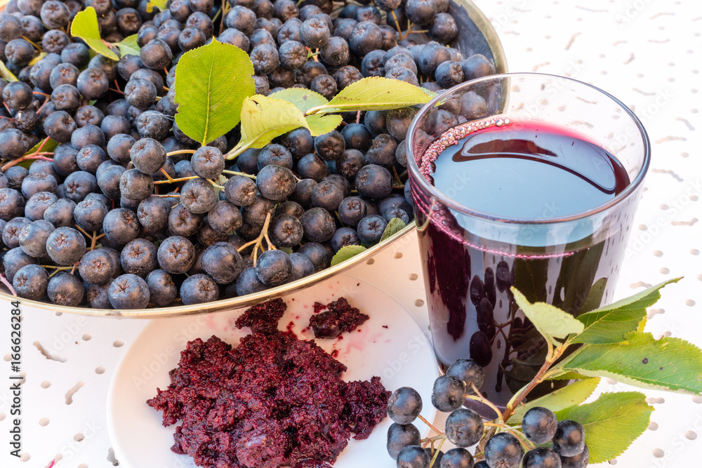 Φωτογραφία Closeup of fresh juice and jam of ripe black chokeberry (Aronia melanocarpa) in