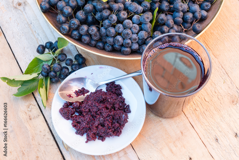 Φωτογραφία Closeup of fresh juice and jam of ripe black chokeberry (Aronia melanocarpa