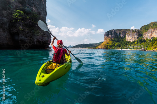 Woman paddles kayak in the tropical sea photo