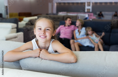 Girl is happy of the purchase of a new sofa