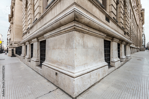 Angle of the corner of a neoclassical building with both sidewalks