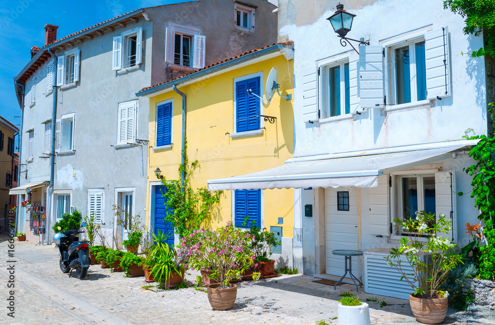 Traditional European Mediterranean architectural style in the streets and residential houses, yard, porches, stairs, shutters in the noon sunbeam, surrounded by vine, rhododendron at summertime.