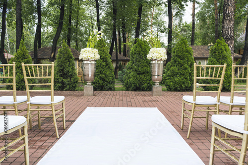 Outdoor wedding of a park. Wedding arch and chairs are on display