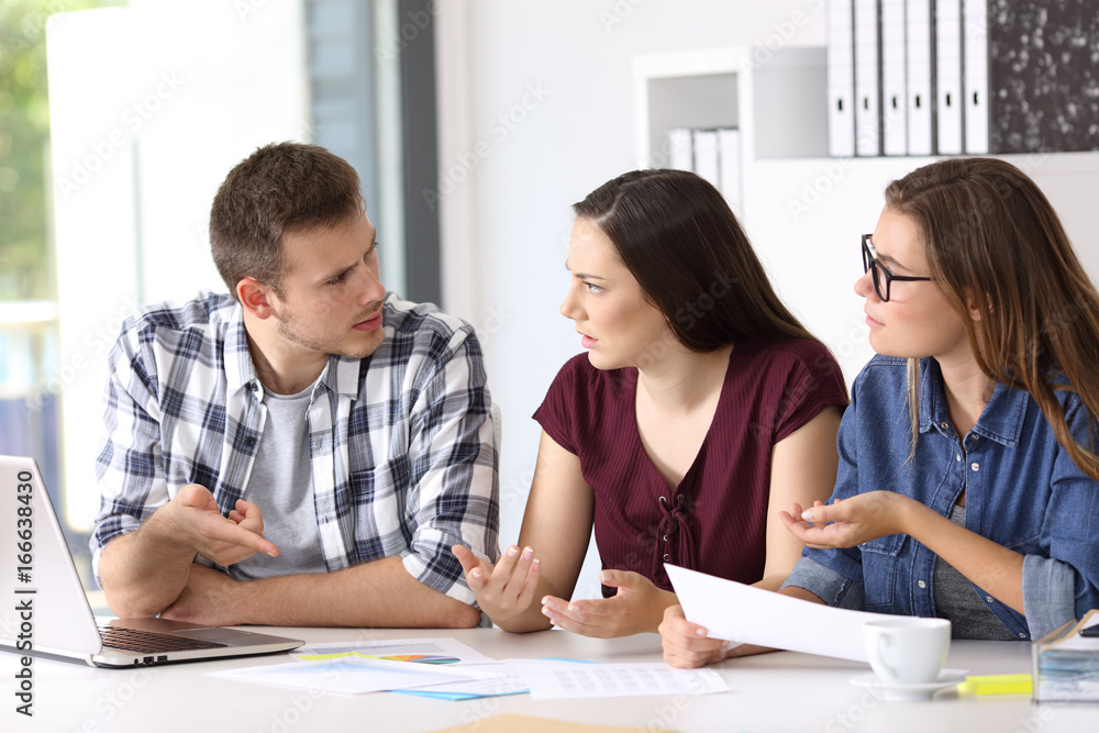 Employees having a job conversation at office Employees having a job conversation at office