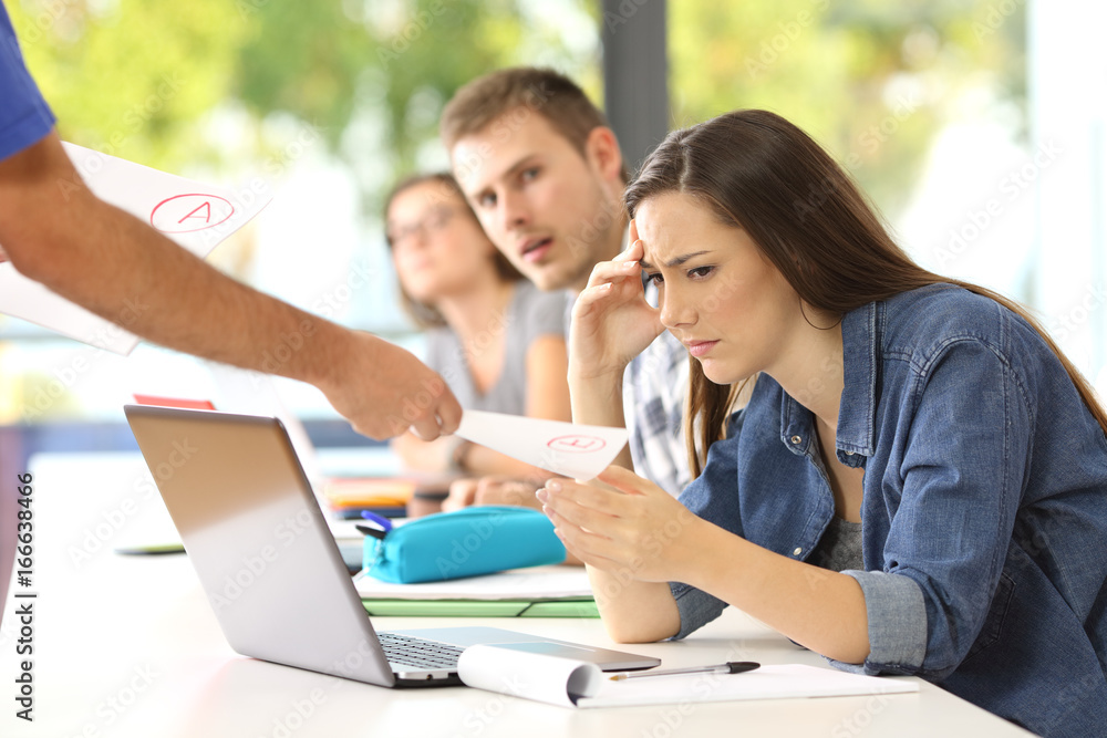 Student receiving a failed exam in a classroom Student receiving a failed exam in a classroom
