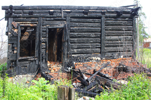 Burned down wooden house, charred walls, burnt roof, black ceilings