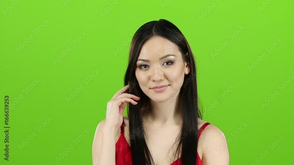 Girl in a red dress flirts, sends kisses and smiles. Green screen. Slow motion Girl in a red dress flirts, sends kisses and smiles. Green screen. Slow motion