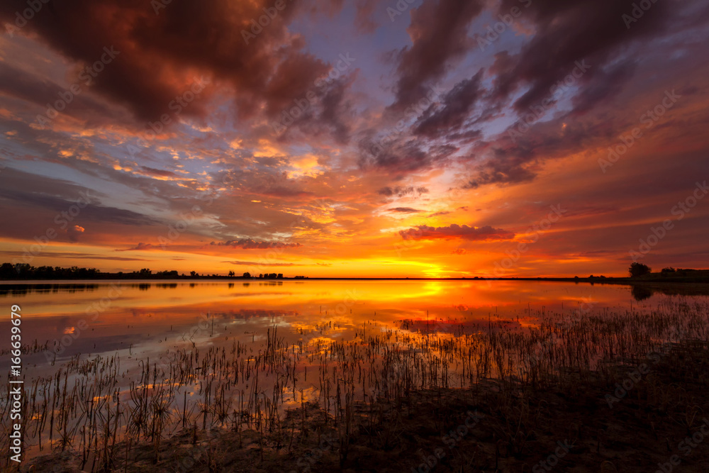 Fototapeta premium Vivid Colorful sunrise or sunset reflecting in a lake