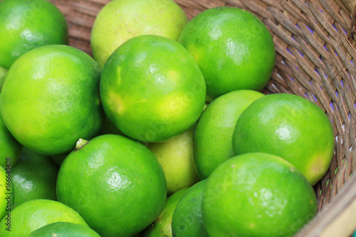 group of Fresh organic green lime Citrus lemon in wooden tray, at fresh market on asian fruit section 