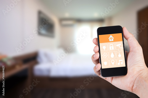 Hand using smartphone to smart home app on mobile for remote control everything in home by wifi network.