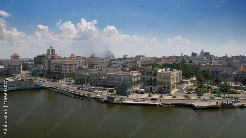 An extreme wide aerial establishing shot of the Port of Havana, Cuba on a sunny summer day. Colorful vintage cars on the streets. The Capitol Dome is seen in the distance. Shot in 5K. An extreme wide aerial establishing shot of the Port of Havana, Cuba on a sunny summer day. Colorful vintage cars on the streets. The Capitol Dome is seen in the distance. Shot in 5K.