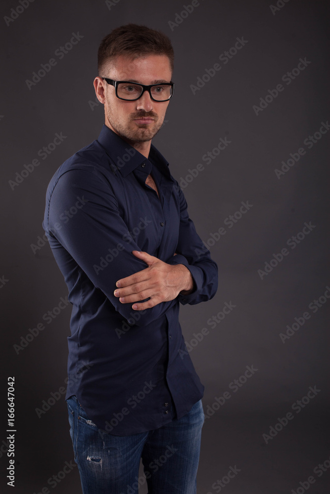 Young confident man portrait of a confident businessman showing by hands on a black background. Ideal for banners, registration forms, presentation, landings, presenting concept. Young confident man portrait of a confident businessman showing by hands on a black background. Ideal for banners, registration forms, presentation, landings, presenting concept.