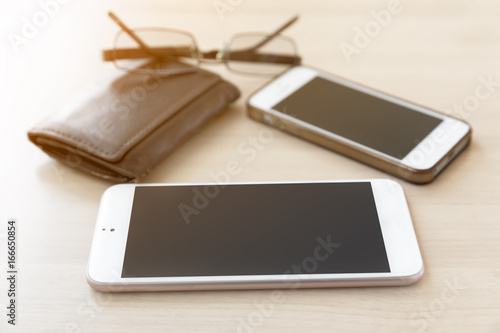 Blank screen phone on wooden table background