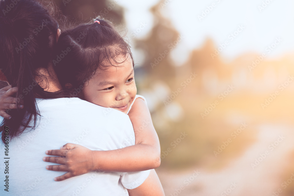 happy asian little child girl hugging her mother with love in the field in vintage color tone happy asian little child girl hugging her mother with love in the field in vintage color tone