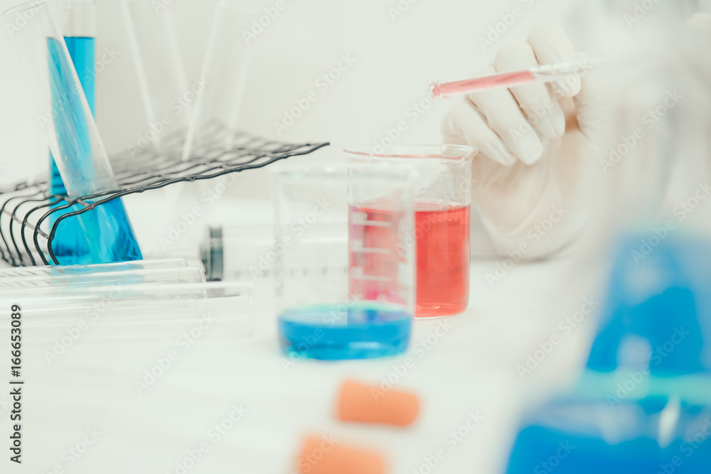 Young Asian scientist working in the lavatory with test tubes and other equipment to discover new drugs, products and methods of formulation Young Asian scientist working in the lavatory with test tubes and other equipment to discover new drugs, products and methods of formulation