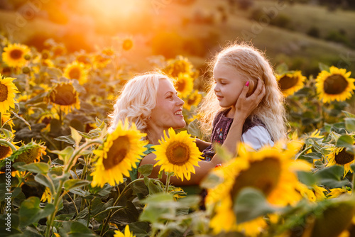 Mom and daughter in the field of sunflowers photo
