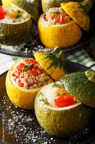 Green zucchini baked with eggs and yellow zucchini stuffed with bulgur close-up. vertical