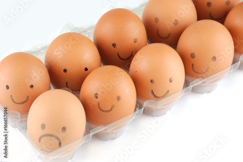 brown eggs with smile and sad face drawing