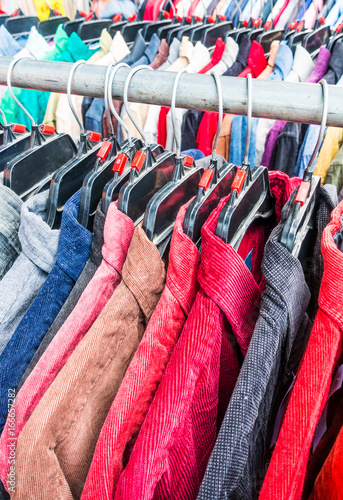 Close up different colorful shirts hanging on rack