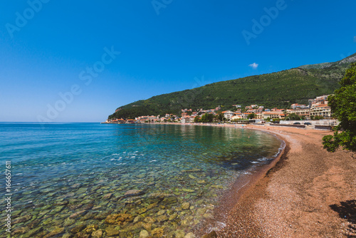 Montenegro landscape with public beach in Petrovac village and sea view. Pebble beach on Montenegrin coast with clear water and by summer day. © krugli