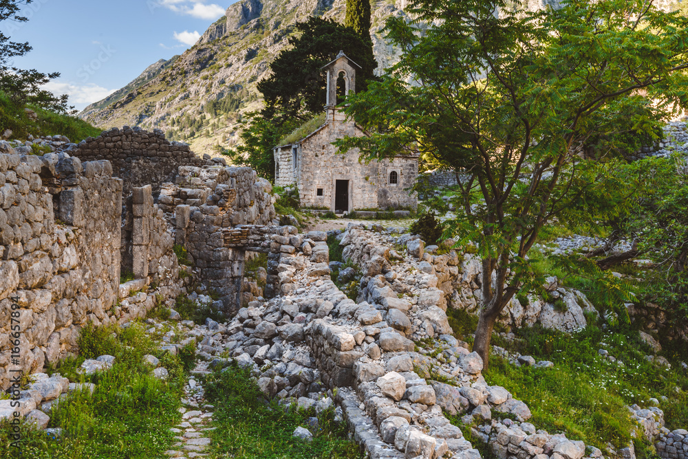 Ancient Serbian church ruins and mountain valley landscape near Kotor castle in Montenegro. Old mountain church and monastery in Kotor Bay region near hike path to Lovchen mountain. Saint Ivan chapel.