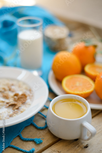 Healthy breakfast, fruit, corn flakes, milk and orange juice on the wooden table