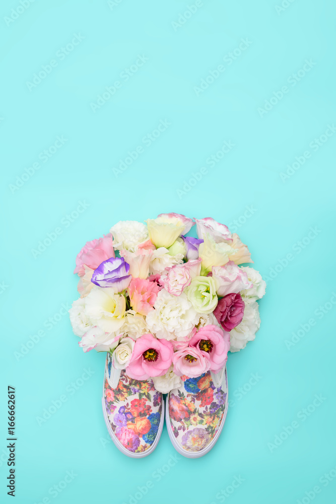 Beautiful gumshoes with flowers inside on bright background Beautiful gumshoes with flowers inside on bright background