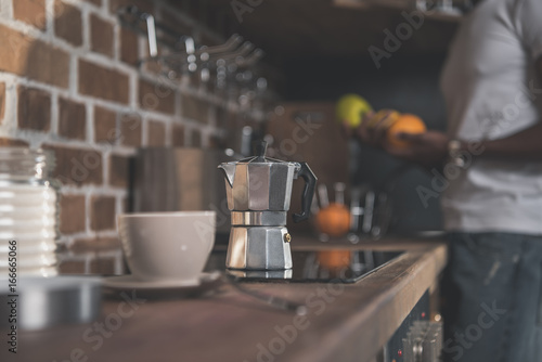 Cup and coffee pot on kitchen table