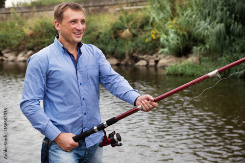 Man fishing using rod on lake