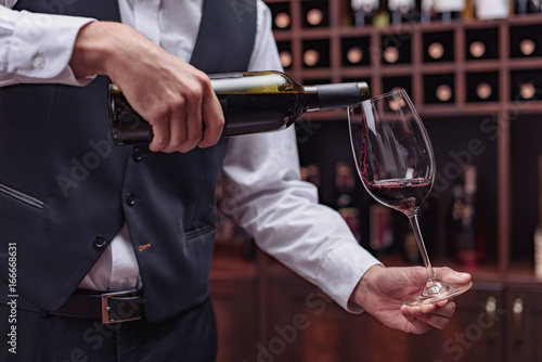 sommelier pouring red wine