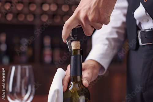 waiter opening wine bottle
