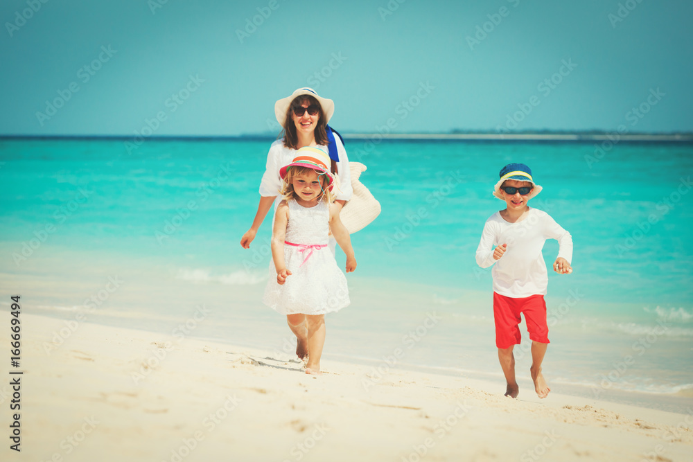 mother with little son and daughter walk on beach mother with little son and daughter walk on beach