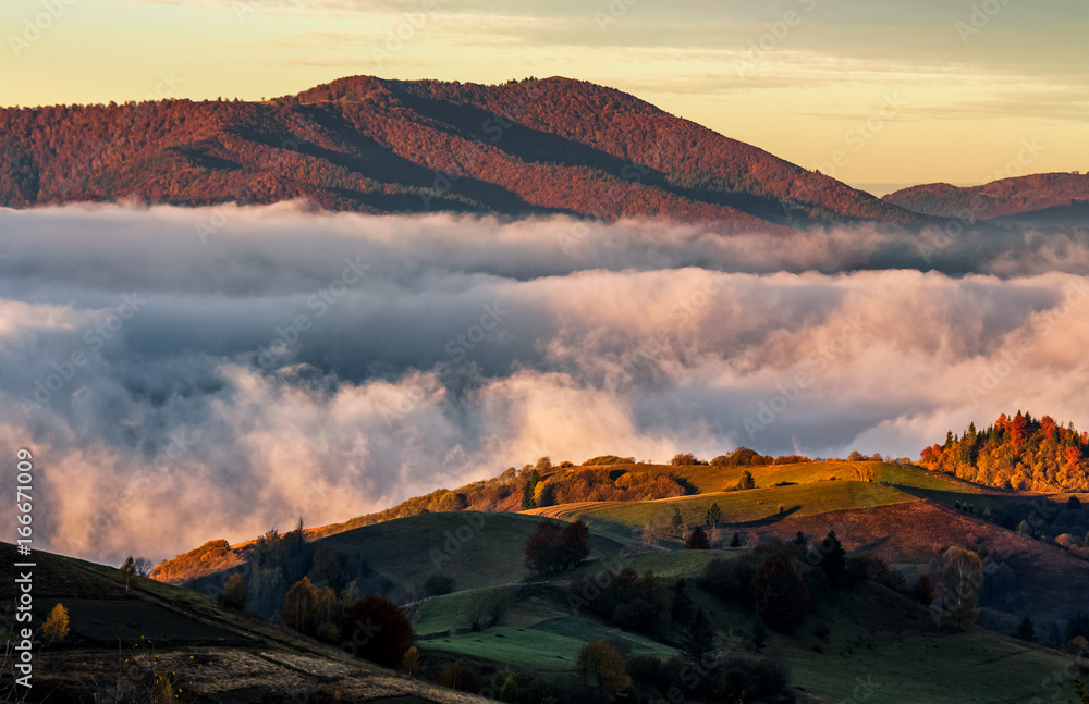 rising clouds in mountainous countryside at sunrise